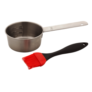 Stainless steel sauce cup with measurements and a black-handled, red silicone basting brush for grilling.