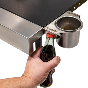 Silver Char-Broil bottle opener attached to grill with hand using it.
