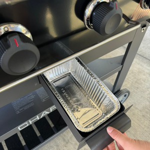 Black Char-Broil electric grill with control knobs and drip pan.